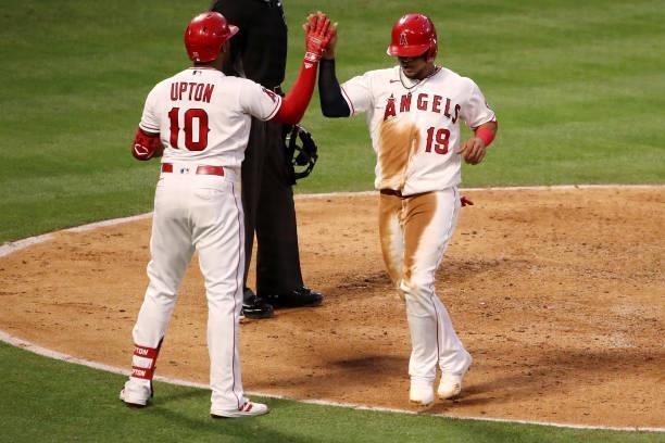 Juan Lagares of the Los Angeles Angels celebrates a run scored with Justin Upton during the fourth inning against the Kansas City Royals at Angel...