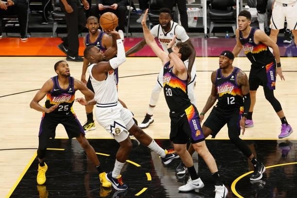 Paul Millsap of the Denver Nuggets attempts a shot over Dario Saric of the Phoenix Suns during the first half in Game One of the Western Conference...