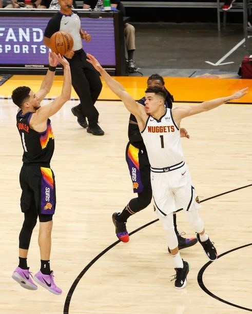 Devin Booker of the Phoenix Suns puts up a three-point shot over Michael Porter Jr. #1 of the Denver Nuggets during the second half in Game One of...