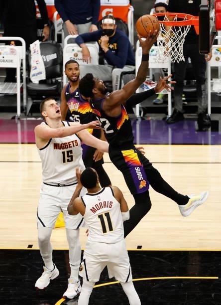 Deandre Ayton of the Phoenix Suns lays up a shot past Nikola Jokic of the Denver Nuggets during the second half in Game One of the Western Conference...