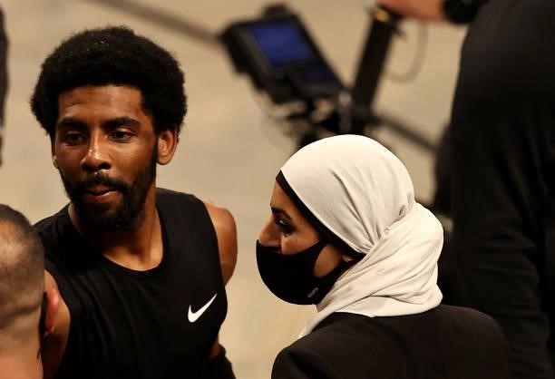Kyrie Irving of the Brooklyn Nets talks to Manhattan district attorney candidate Tahanie Aboushi after game two of the Eastern Conference second...