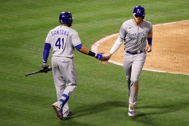 Hunter Dozier of the Kansas City Royals celebrates his run scored with Carlos Santana during the seventh inning against the Los Angeles Angels at...