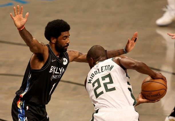 Kyrie Irving of the Brooklyn Nets tries to keep Khris Middleton of the Milwaukee Bucks from taking a shot in the first quarter during game two of the...