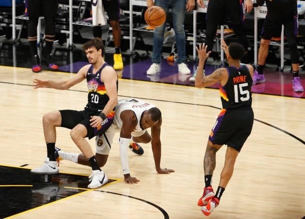 Dario Saric of the Phoenix Suns passes the ball to Cameron Payne under pressure from Paul Millsap of the Denver Nuggets during the second half in...