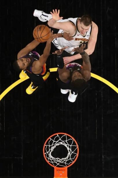 Nikola Jokic of the Denver Nuggets puts up a shot over Mikal Bridges and Deandre Ayton of the Phoenix Suns during the second half in Game One of the...