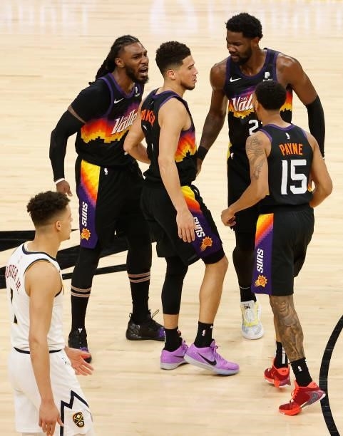 Devin Booker of the Phoenix Suns is congratulated by Jae Crowder, Deandre Ayton and Cameron Payne after scoring against the Denver Nuggets during the...