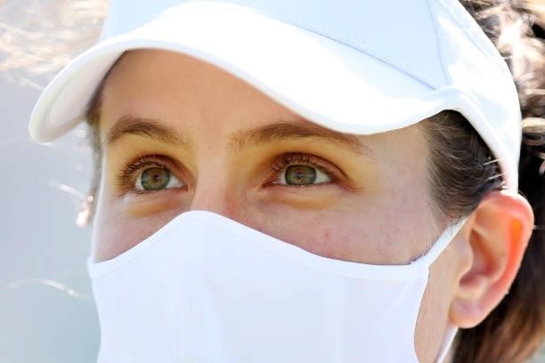 Johanna Konta of Great Britain wears a face mask as she looks on after victory against Lesley Pattinama Kerkhove of the Netherlands during Day 4 of...