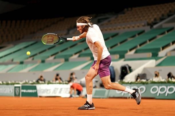 Stefanos Tsitsipas of Greece plays a backhand in their mens singles quarter final match against Daniil Medvedev of Russia during day ten of the 2021...