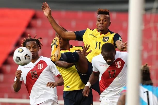 Michael Estrada of Ecuador fights for the ball with Luis Advíncula of Peru and André Carrillo of Peru during a match between Ecuador and Peru as part...