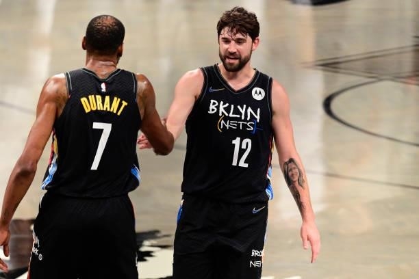 Joe Harris of the Brooklyn Nets congratulates Kevin Durant on his basket against the Milwaukee Bucks in Game Two of the Second Round of the 2021 NBA...