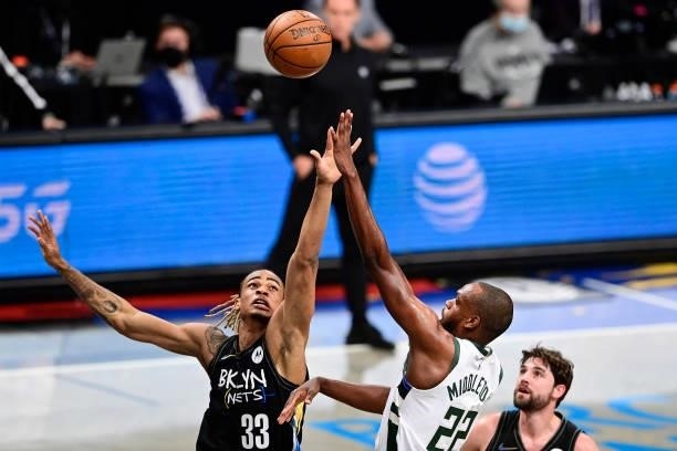 Khris Middleton of the Milwaukee Bucks attempts a shot against Nicolas Claxton of the Brooklyn Nets in Game Two of the Second Round of the 2021 NBA...