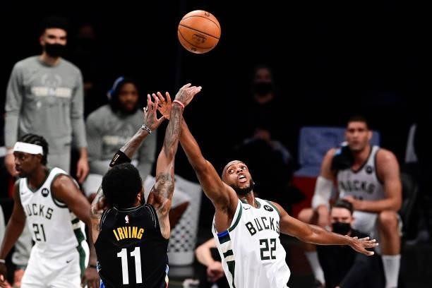 Kyrie Irving of the Brooklyn Nets attempts a jump shot against Khris Middleton of the Milwaukee Bucks in Game Two of the Second Round of the 2021 NBA...
