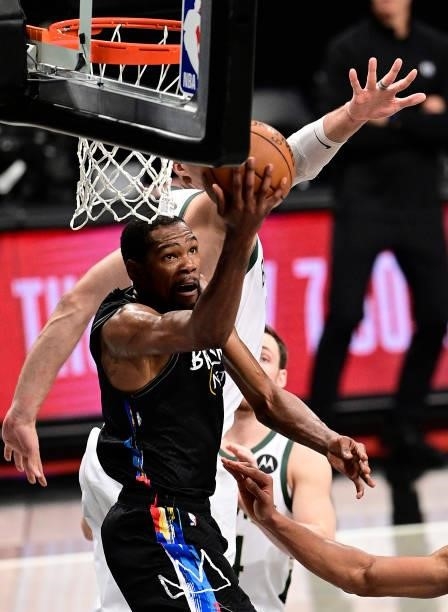 Kevin Durant of the Brooklyn Nets scores on a reverse-layup against Brook Lopez of the Milwaukee Bucks in Game Two of the Second Round of the 2021...