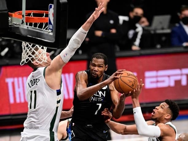 Kevin Durant of the Brooklyn Nets scores on a reverse-layup against Brook Lopez of the Milwaukee Bucks in Game Two of the Second Round of the 2021...