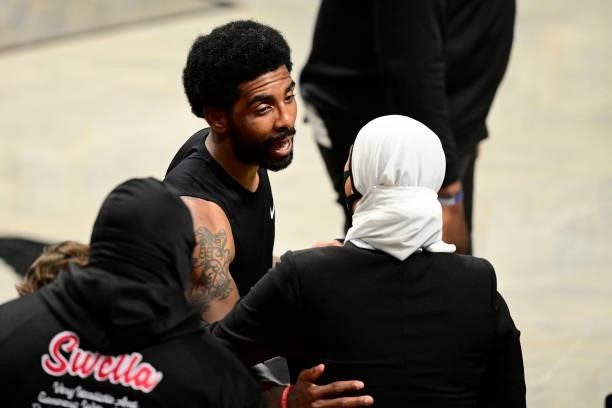 Kyrie Irving of the Brooklyn Nets talks to Manhattan district attorney candidate Tahanie Aboushi following his teams win against the Milwaukee Bucks...