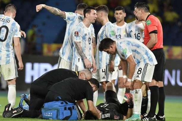 Lionel Messi of Argentina talks to referee Roberto Tobar as Emiliano Martinez Goalkeeper of Argentina receives medical attention after receiving a...