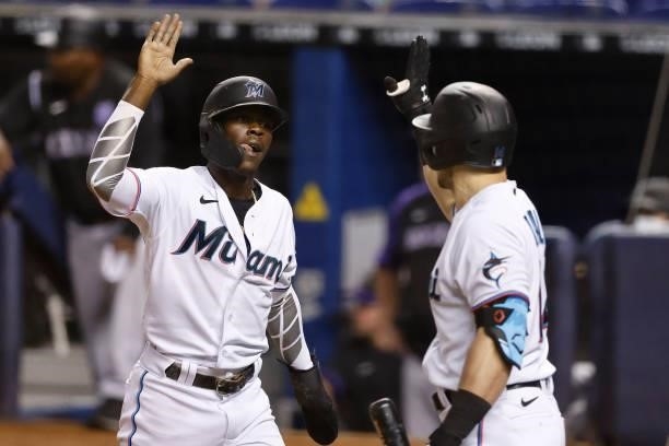Jazz Chisholm Jr. #2 of the Miami Marlins celebrates with Adam Duvall after scoring a run on a triple hit by Corey Dickerson against the Colorado...