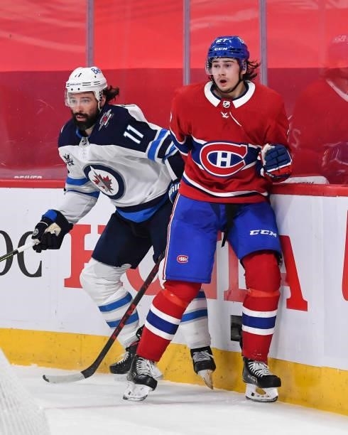 Nate Thompson of the Winnipeg Jets and Alexander Romanov of the Montreal Canadiens skate against each other during the first period in Game Four of...