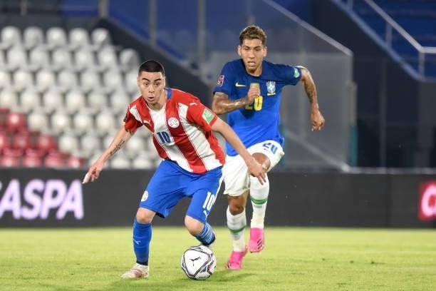 Miguel Almirón of Paraguay competes for the ball with Roberto Firmino of Brazil during a match between Paraguay and Brazil as part of South American...