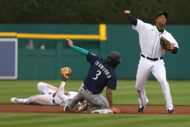 Jonathan Schoop of the Detroit Tigers tries to turn a double play around J.P. Crawford of the Seattle Mariners during the first inning at Comerica...