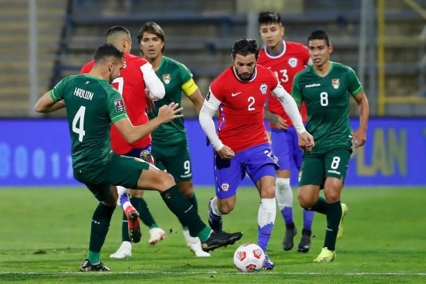 Eugenio Mena of Chile dribbles past Luís Haquin of Bolivia during a match between Chile and Bolivia as part of South American Qualifiers for Qatar...