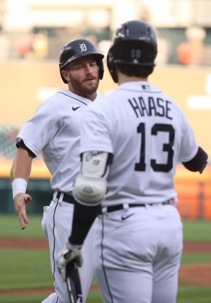 Robbie Grossman of the Detroit Tigers celebrates scoring a first inning run with Eric Haase while playing the Seattle Mariners at Comerica Park on...