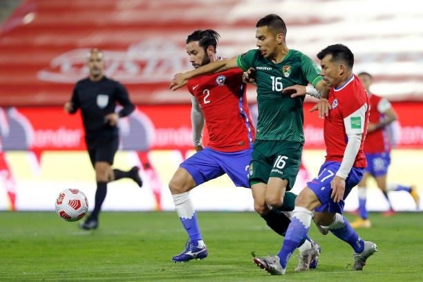 Claudio Baeza of Chile competes for the ball with Eugenio Mena and Gary Medel of Chile during a match between Chile and Bolivia as part of South...