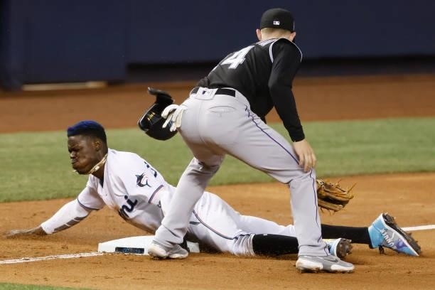 Jazz Chisholm Jr. #2 of the Miami Marlins slides safely into third base past the tag of Ryan McMahon of the Colorado Rockies during the seventh...