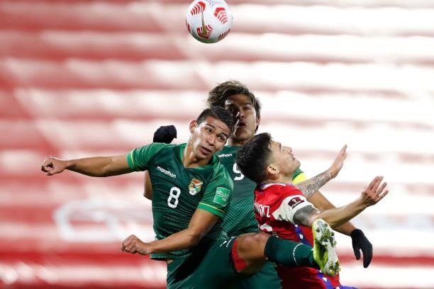 Diego Bejarano of Bolivia jumps for the ball with Charles Aránguiz of Chile during a match between Chile and Bolivia as part of South American...