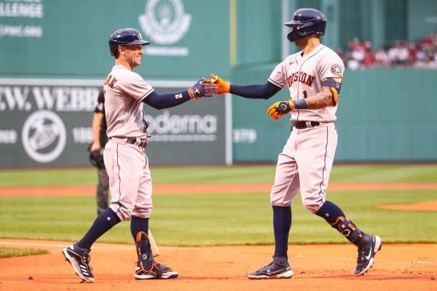 Carlos Correa of the Houston Astros reacts with Alex Bregman of the Houston Astros after hitting a solo home run in the first inning of a game...