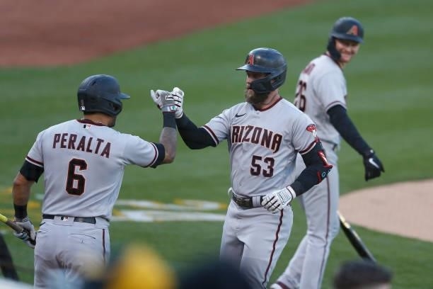 Christian Walker of the Arizona Diamondbacks celebrates with David Peralta after hitting a solo home run in the top of the second inning against the...