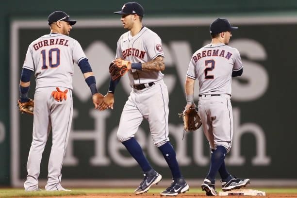 Carlos Correa of the Houston Astros high fives Yuli Gurriel of the Houston Astros after a win over the Boston Red Sox at Fenway Park on June 8, 2021...