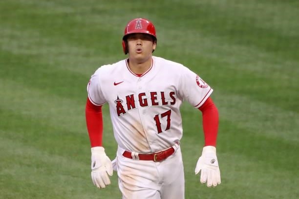 Shohei Ohtani of the Los Angeles Angels reacts after scoring off an RBI single from Anthony Rendon during the first inning against the Kansas City...