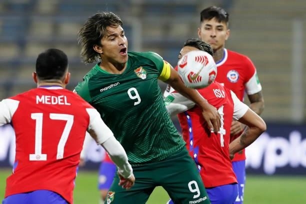 Marcelo Moreno Martins of Bolivia competes for the ball with Gary Medel and Mauricio Isla of Chile during a match between Chile and Bolivia as part...