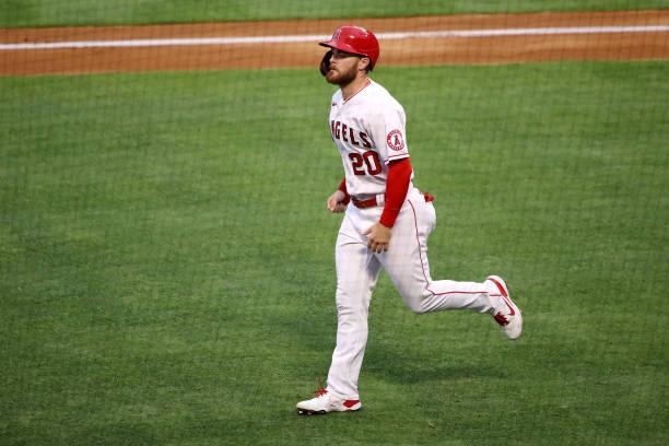 Jared Walsh of the Los Angeles Angels jogs to the dugout after scoring off an RBI sacrifice groundout by Jose Iglesias during the first inning...