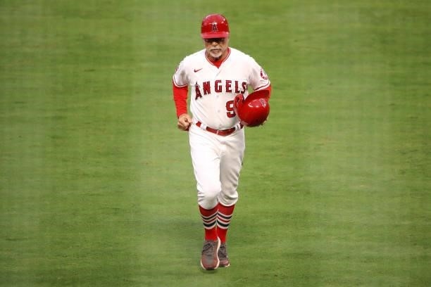 Third base coach Bruce Hines of the Los Angeles Angels jogs to the dugout during the first inning against the Kansas City Royals at Angel Stadium of...