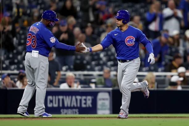 Third base coach Willie Harris congratulates Willson Contreras of the Chicago Cubs after his solo homerun during the fourth inning of a game against...