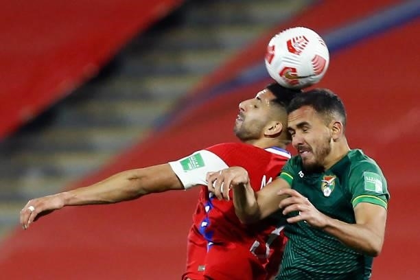 Guillermo Maripán of Chile jumps for the ball with Luís Haquin of Bolivia during a match between Chile and Bolivia as part of South American...
