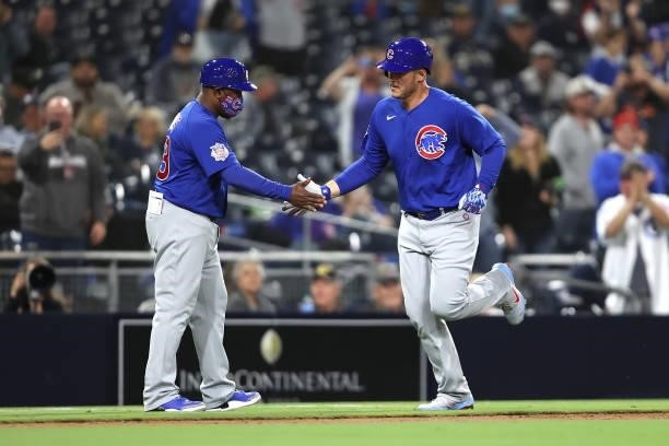Third base coach Willie Harris congratulates Anthony Rizzo of the Chicago Cubs after his two-run homerun in the seventh inning of a game against the...