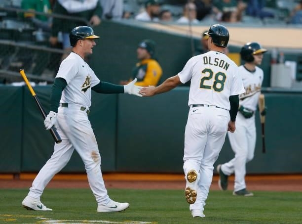 Matt Olson of the Oakland Athletics celebrates with Matt Chapman after scoring on a single by Chad Pinder in the bottom of the fourth inning against...