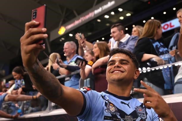 Latrell Mitchell of the Blues poses with fans after winning game one of the 2021 State of Origin series between the New South Wales Blues and the...