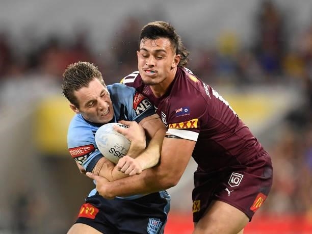 Cameron Murray of the Blues is tackled by Tino Fa'asuamaleaui of the Maroons during game one of the 2021 State of Origin series between the New South...