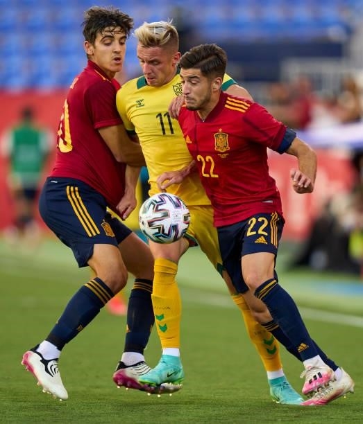 Oscar Gil and Gonzalo Villar of Spain U21 battle for the ball with Arvydas Novikovas of Lithuania during the international friendly match between...