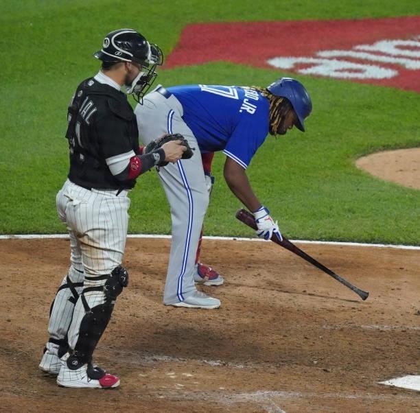Yasmani Grandal of the Chicago White Sox watches as Vladimir Guerrero Jr. #27 of the Toronto Blue Jays makes some marks in the dirt before batting...