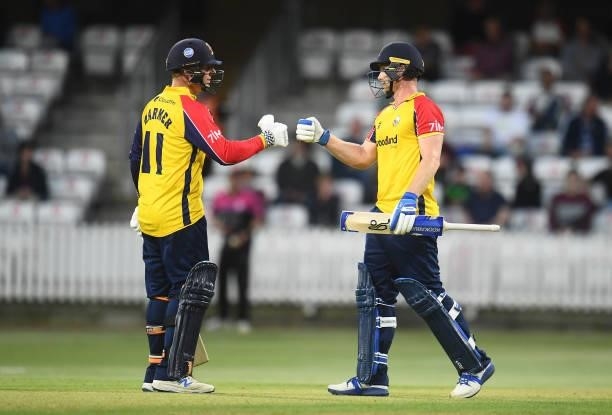 Jimmy Neesham of Essex celebrates after reaching their half century with team mate Simon Harmer during the Vitality T20 Blast match between Somerset...