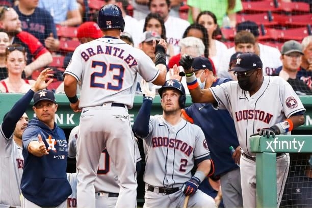 Carlos Correa reacts with Alex Bregman of the Houston Astros after hitting a solo home run in the first inning of a game against the Boston Red Sox...