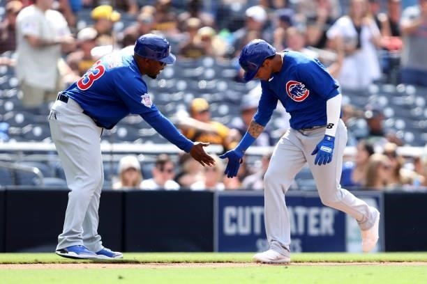 Third base coach Willie Harris congratulates Sergio Alcantara of the Chicago Cubs after his solo homerun during the eighth inning of a game against...