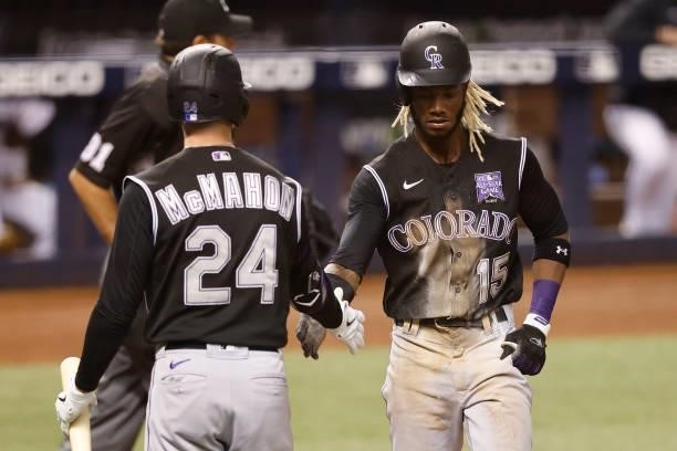 Raimel Tapia of the Colorado Rockies celebrates with Ryan McMahon after scoring on a passed ball during the fifth inning against the Miami Marlins at...