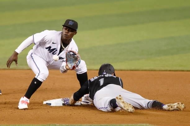 Garrett Hampson of the Colorado Rockies steals second base ahead of the throw to Jazz Chisholm Jr. #2 of the Miami Marlins during the fourth inning...