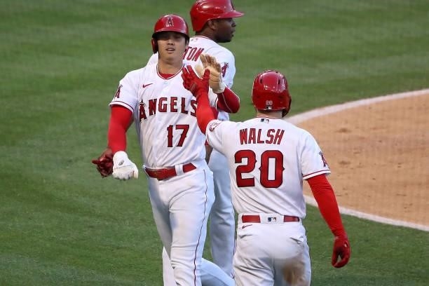 Shohei Ohtani and Jared Walsh of the Los Angeles Angels celebrate runs scored off a two RBI double by Anthony Rendon during the third inning against...